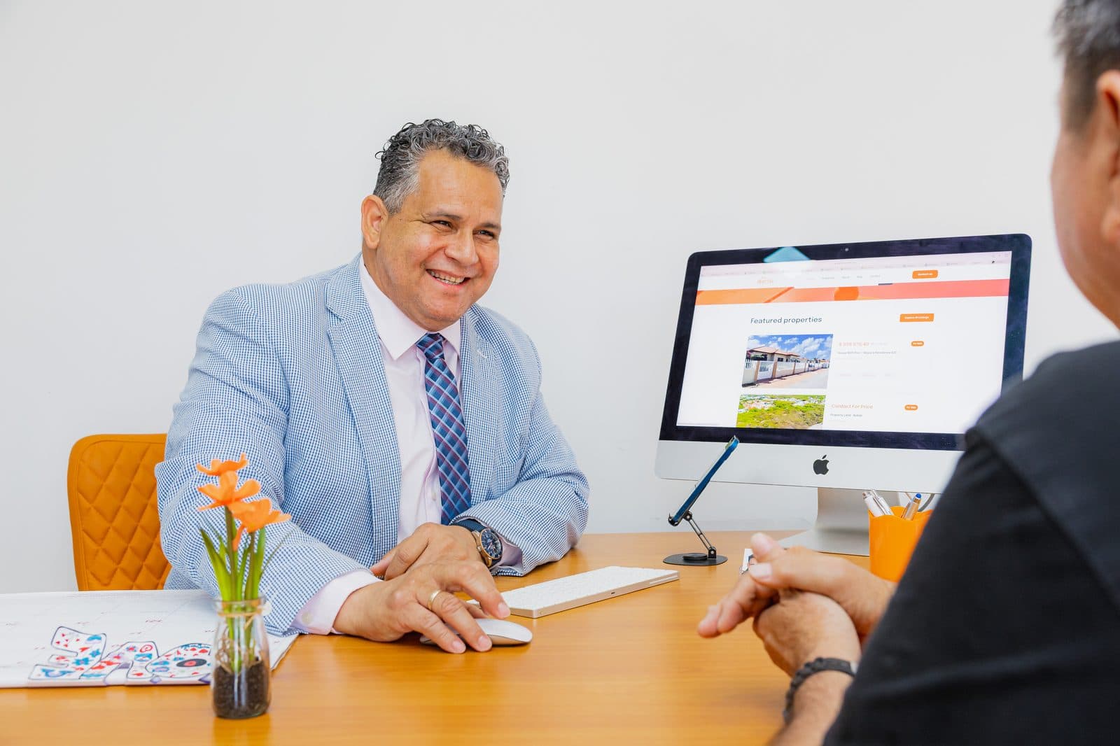 Lionel Croes advising a client at the Objective Realty office in Aruba