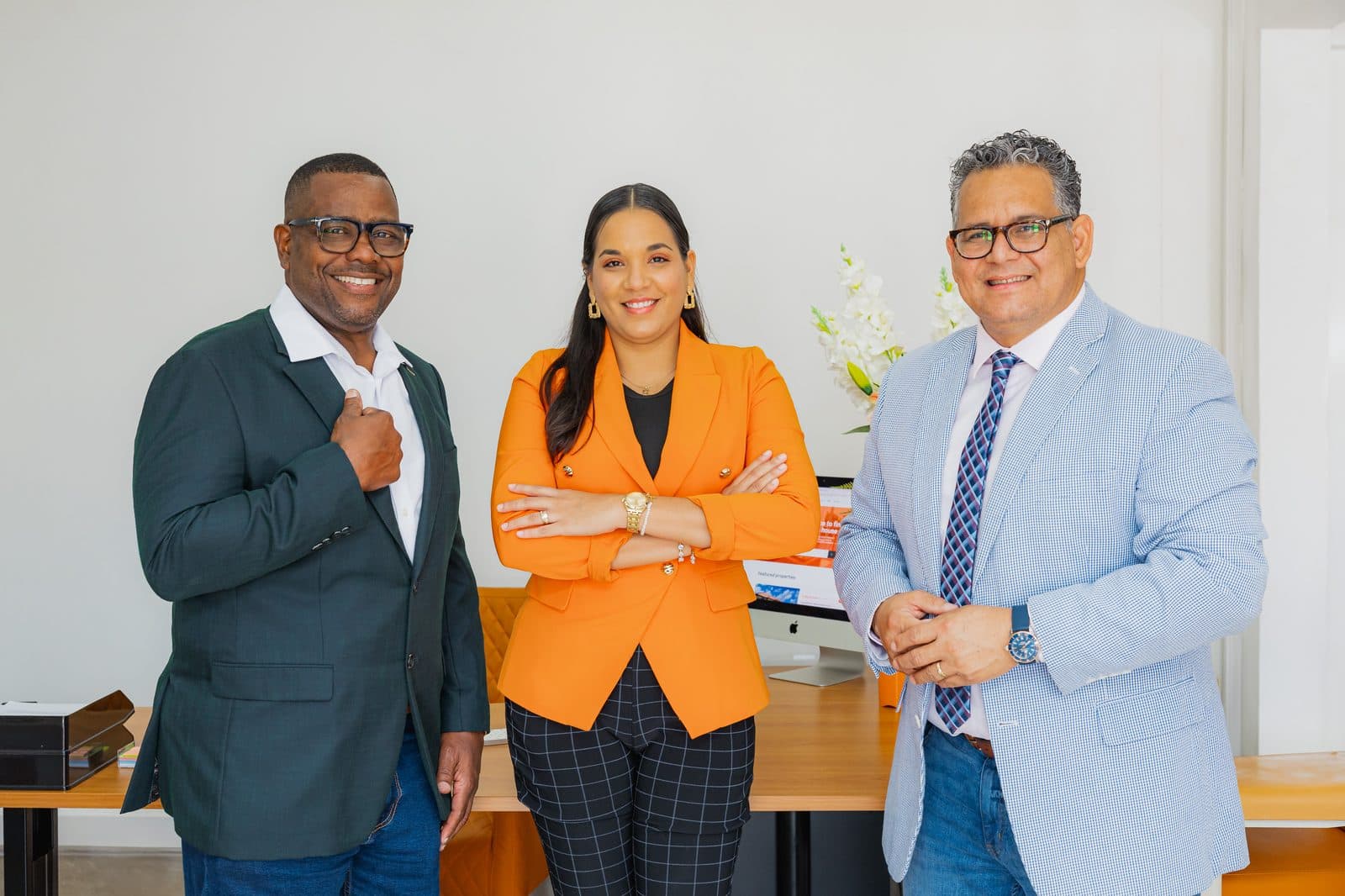The Objective Realty team standing together in their Aruba office